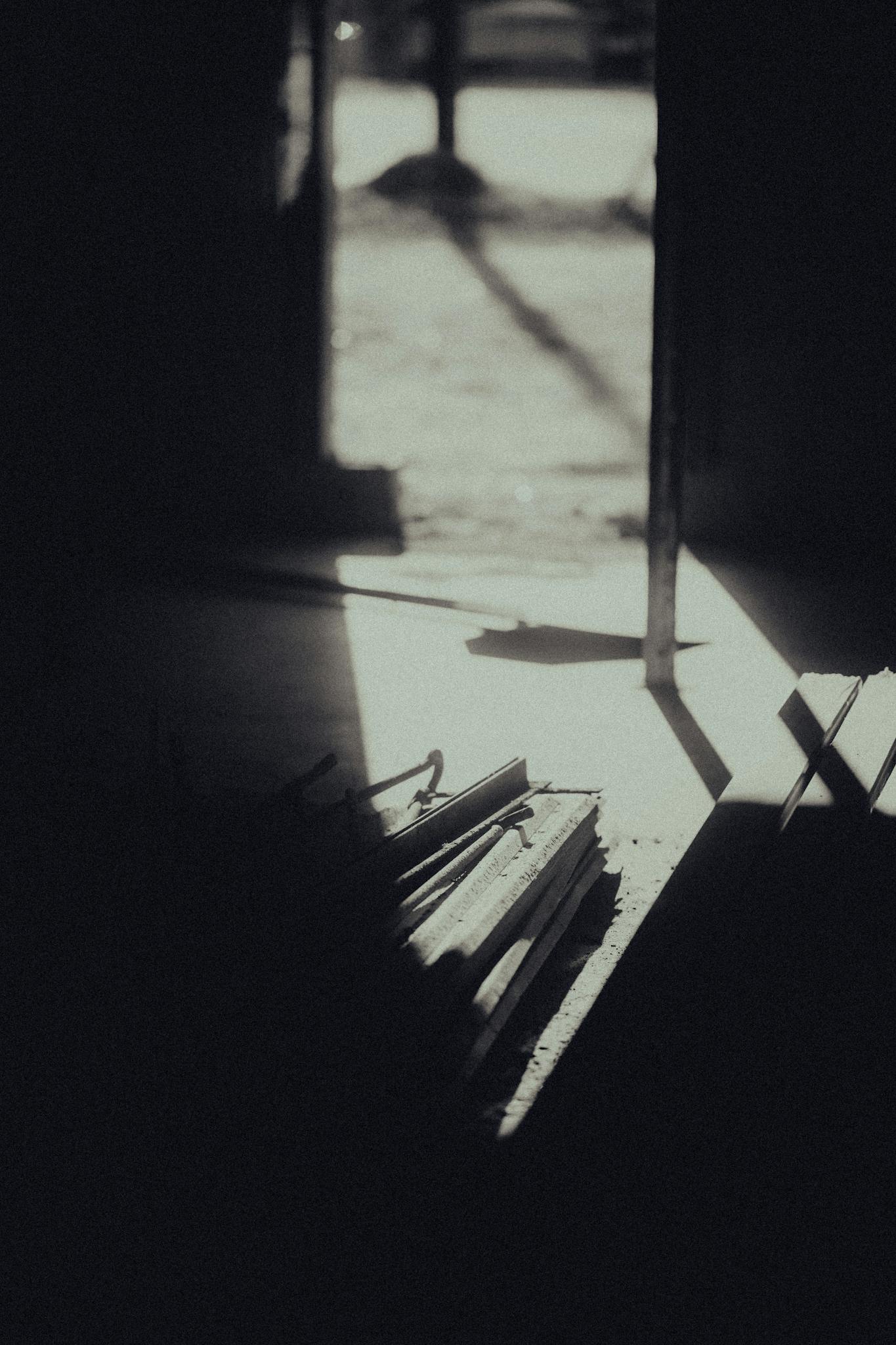 A serene black and white interior, showcasing dramatic light and shadow play through an open door.