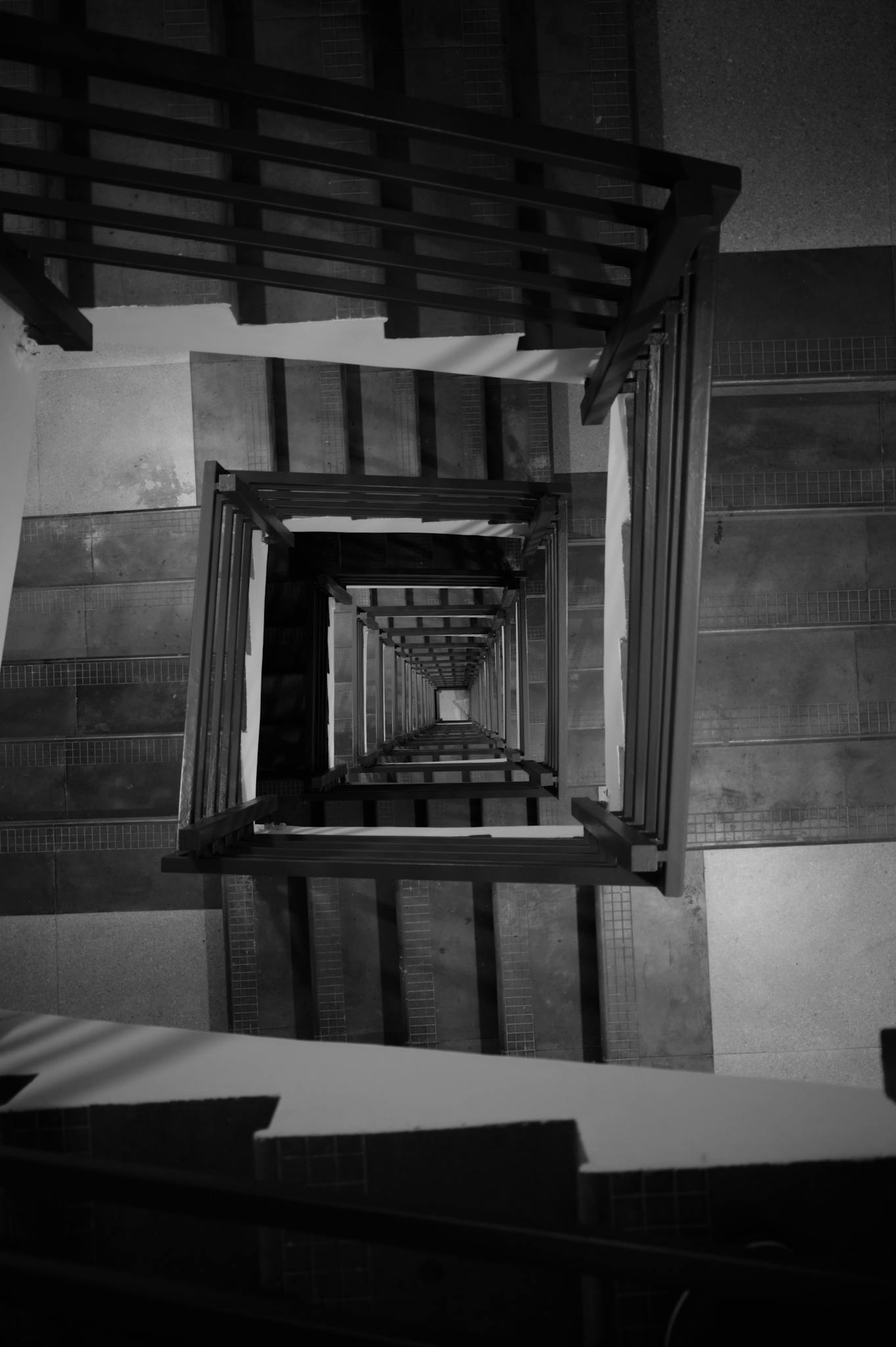 Black and white view of a spiral staircase in Bengaluru, India, showcasing symmetry and design.