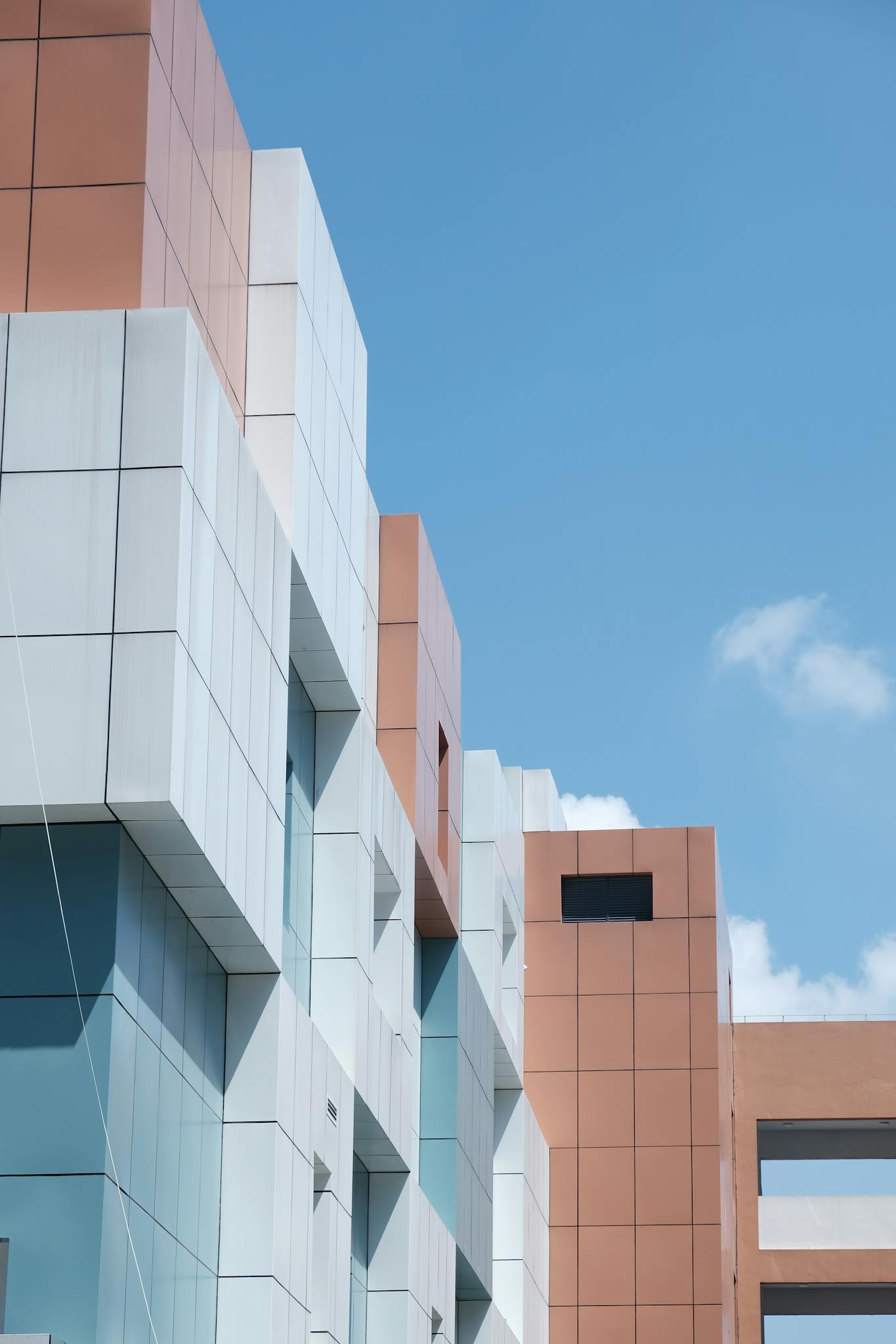 Minimalist urban architecture with geometric forms and vibrant sky backdrop.