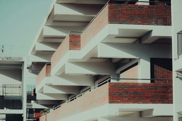 Modern apartment building with geometric design and brick facade.