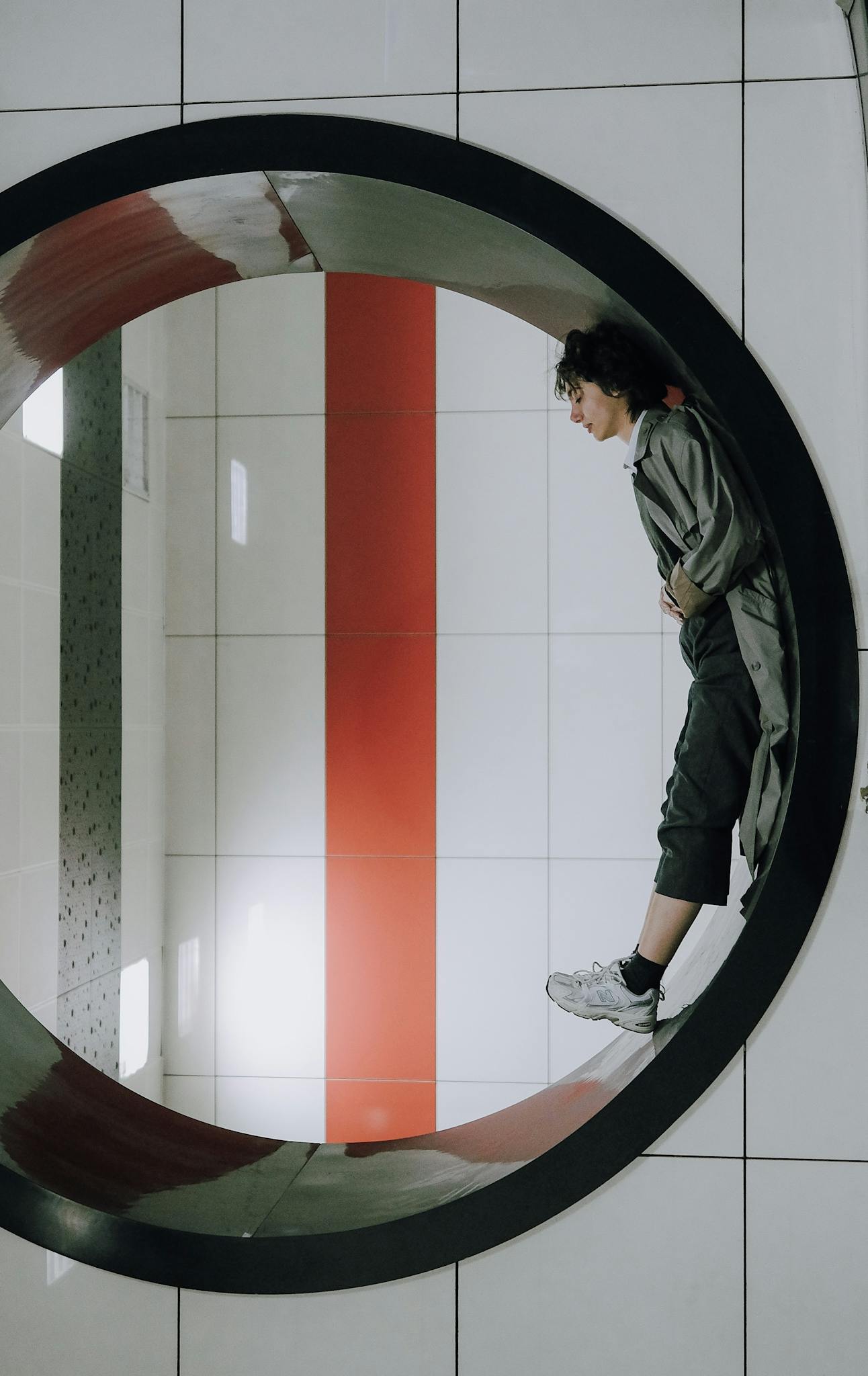 Person standing within a circular design at subway station showcasing modern architecture.